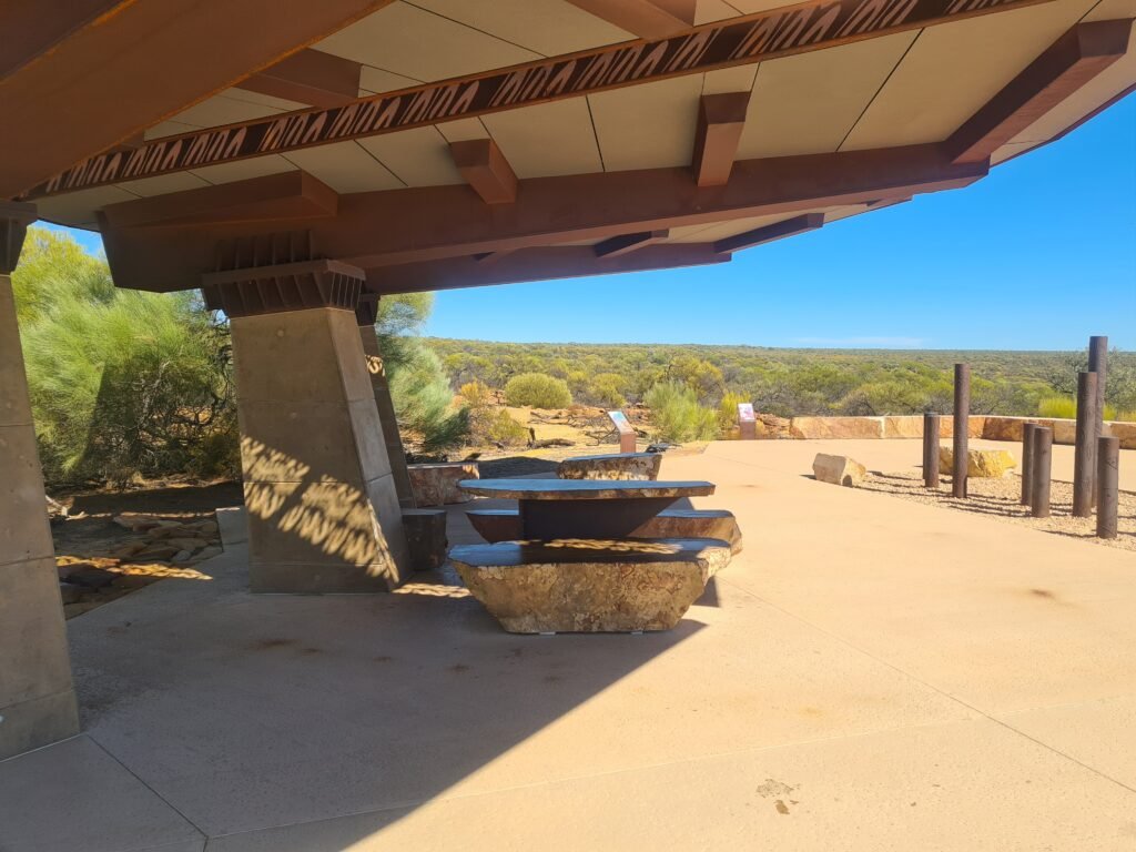 Shaded picnic area at Kalbarri Skywalk with stone tables and outback views